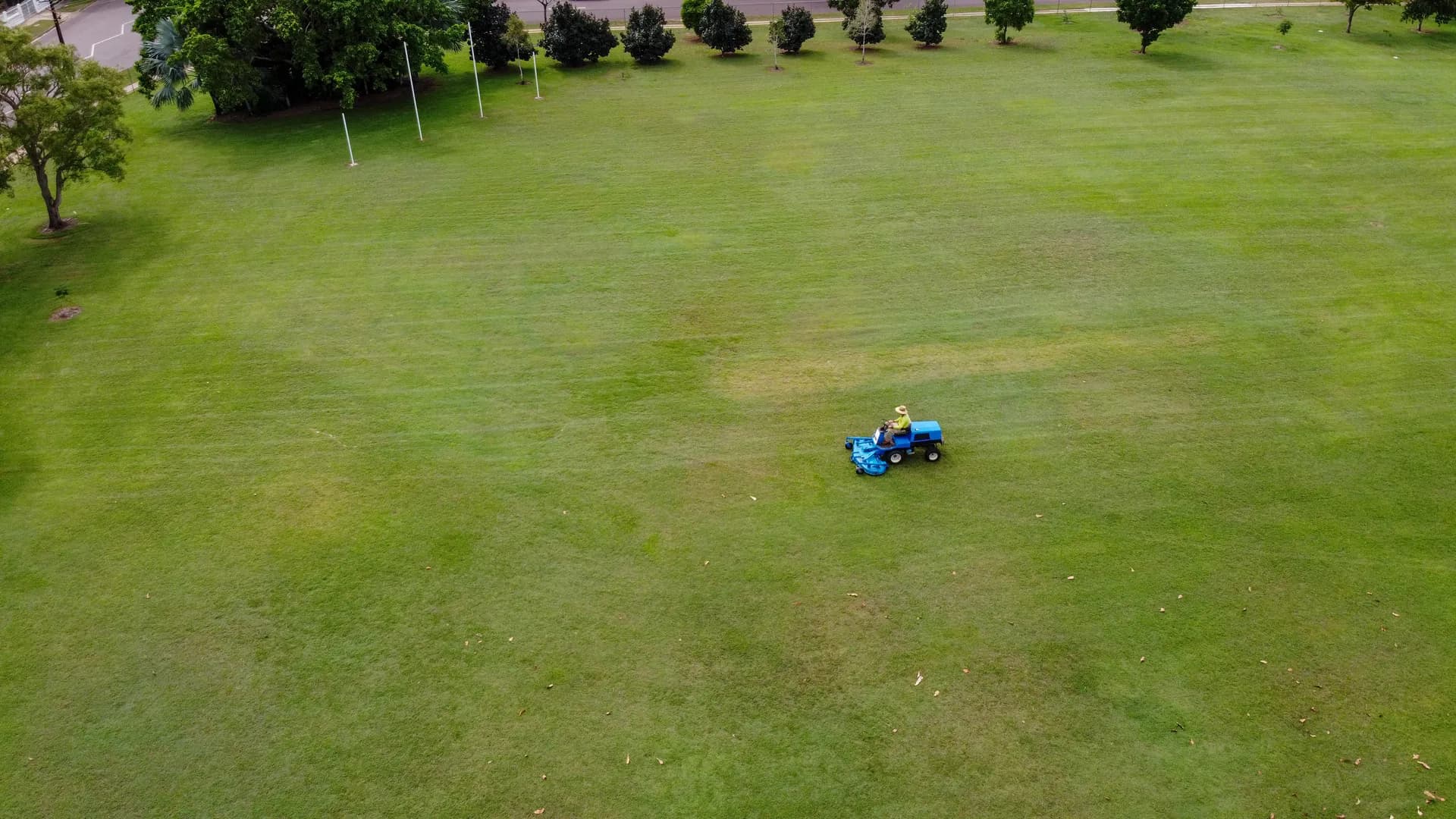 Aerial view of tree-lined sports field maintenance